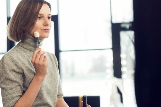 A woman applying loose powder to her face with a large, fluffy powder brush, focusing on the T-zone area.