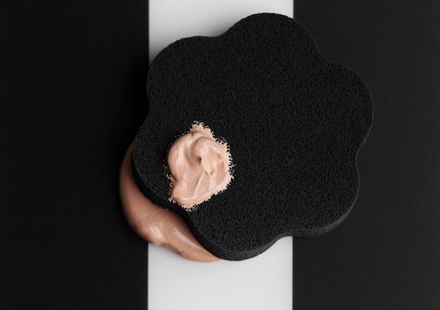 A close-up of a beauty sponge with a small amount of liquid foundation applied to its rounded surface, ready to be applied to the face.